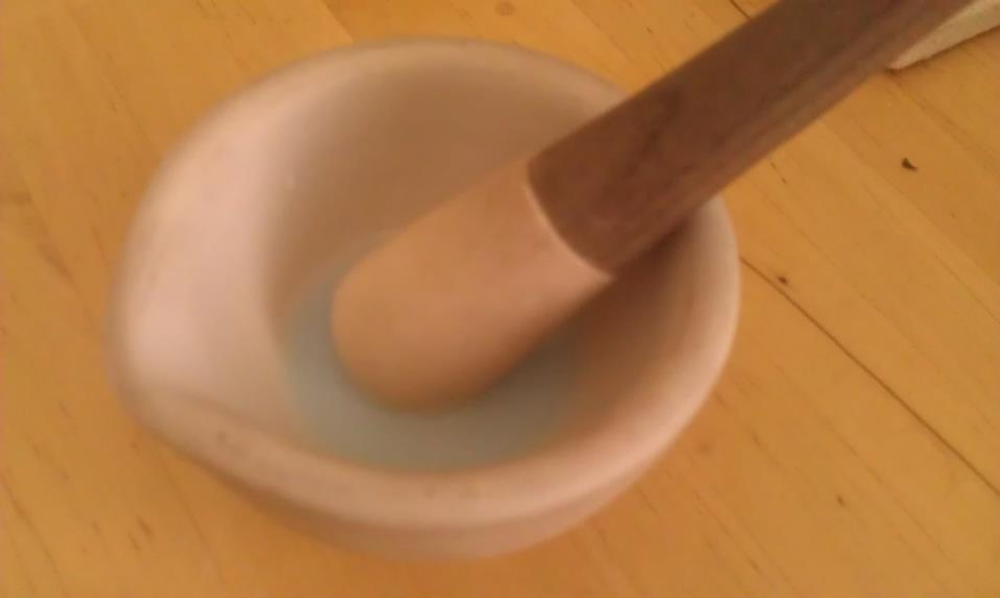Ground enamel powder with a pestle resting on top