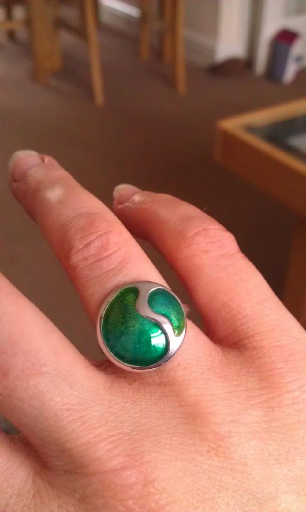 Finished silver and green enamel ring modelled on a hand