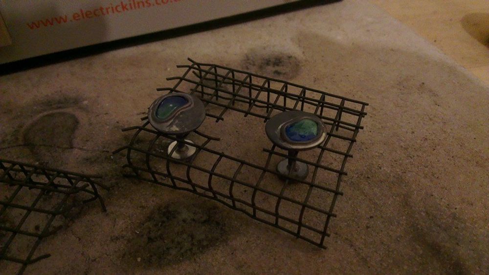 Silver cufflinks sat in wire cooling rack