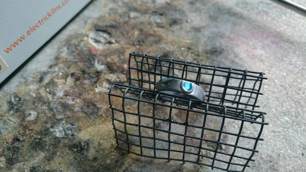 Silver ring with enamel sat on cooling rack