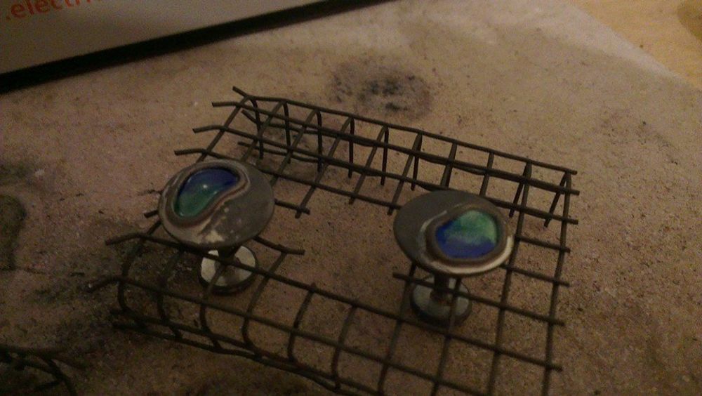 Silver cufflinks sat in wire cooling rack