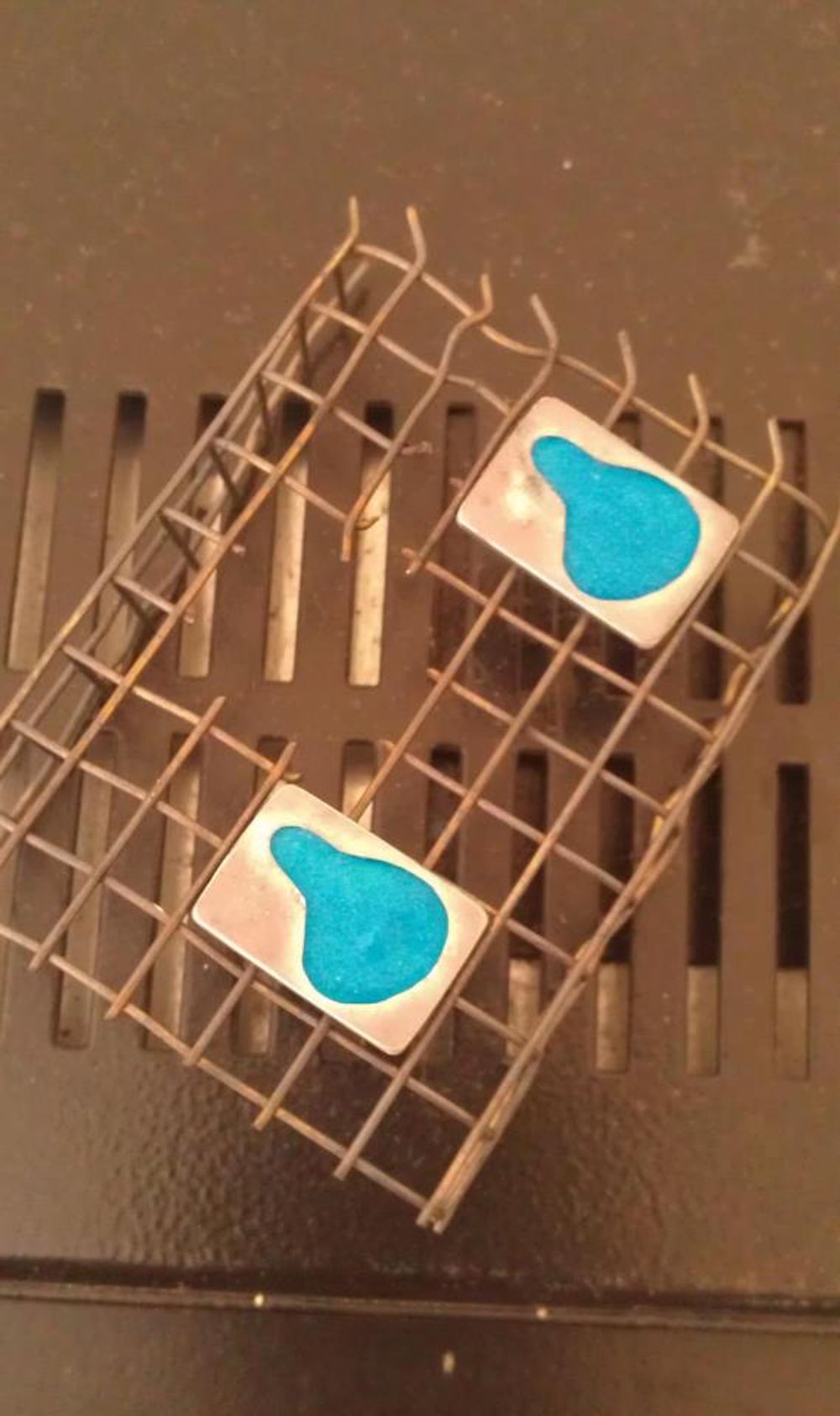 Enamelled pendants drying out on top of kiln