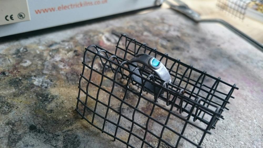 Silver ring with enamel sat on cooling rack