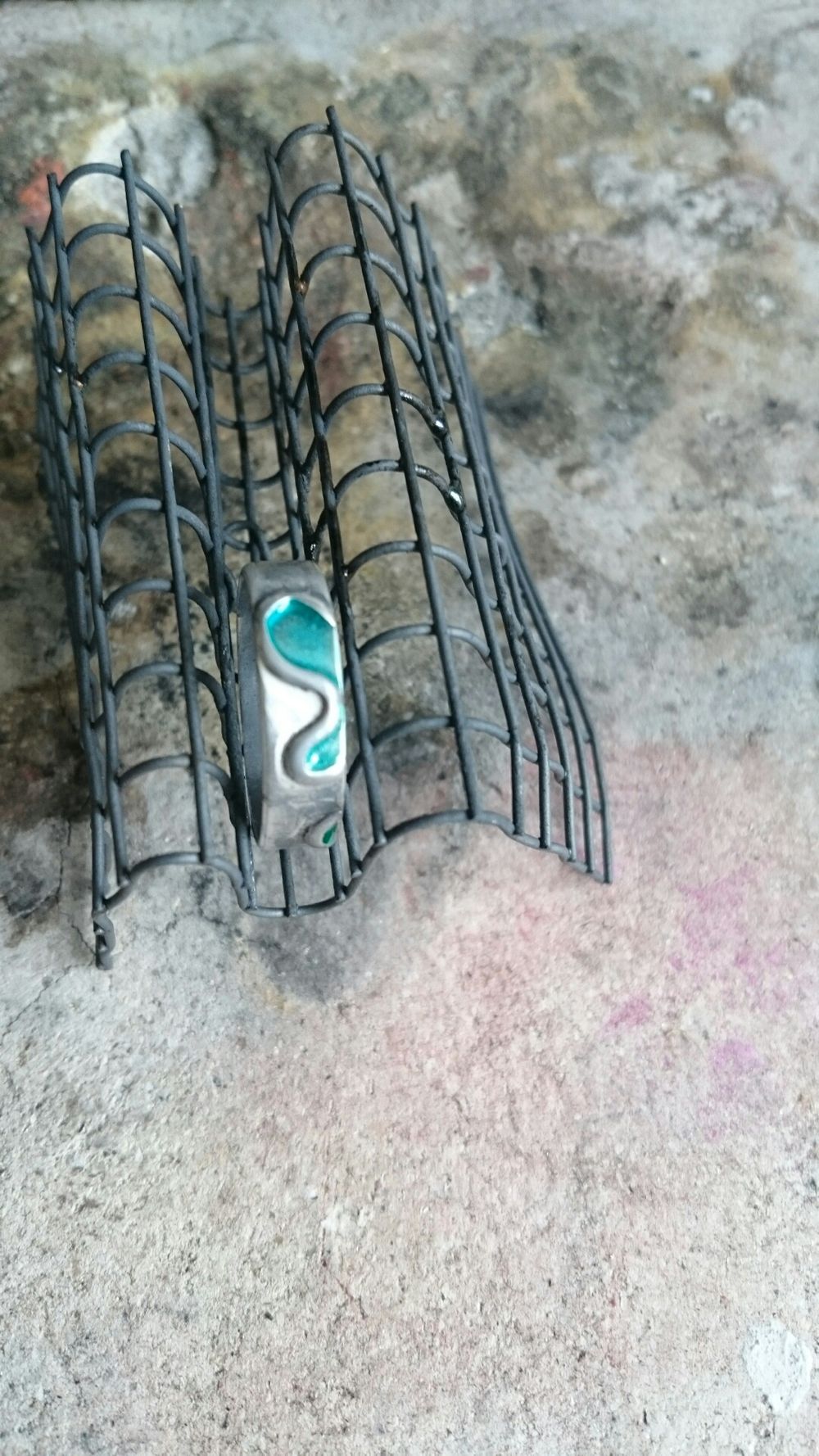 Silver ring with enamel sat on cooling rack