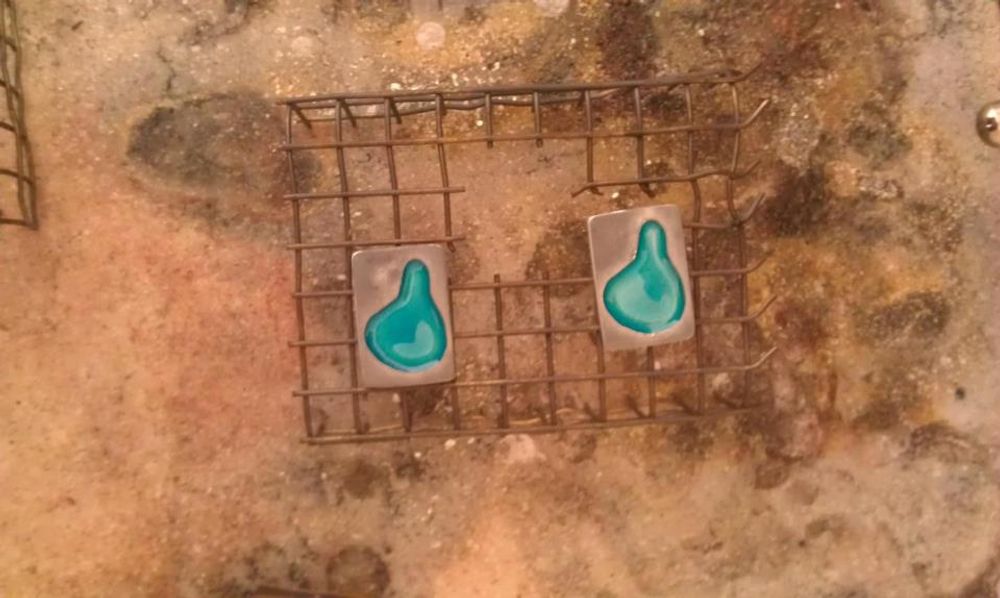 Enamelled silver pendants cooling down on wire rack