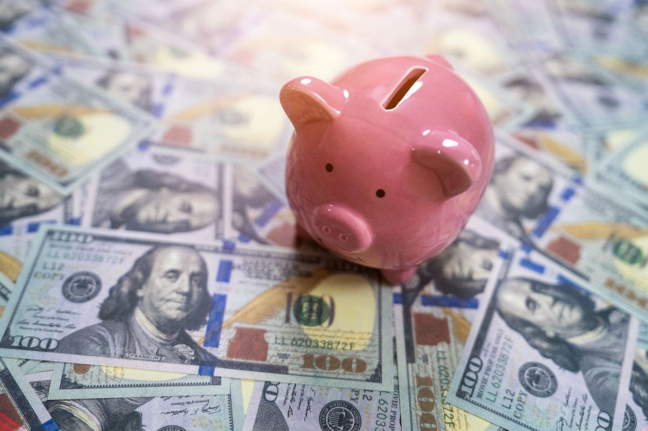 Piggy bank on top of paper money