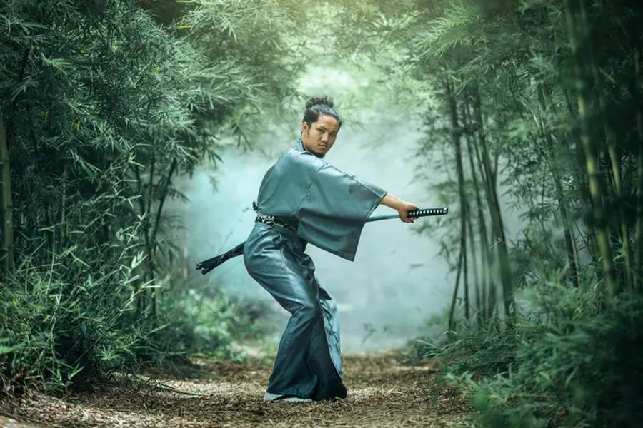 A samurai about to draw his sword in a forest