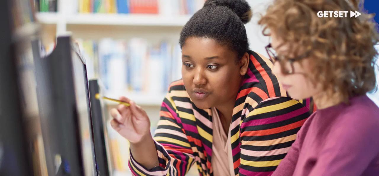 Teacher and student looking at a computer