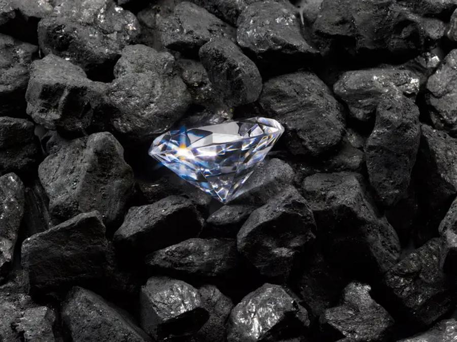 A bright, sparkling diamond amongst black rocks