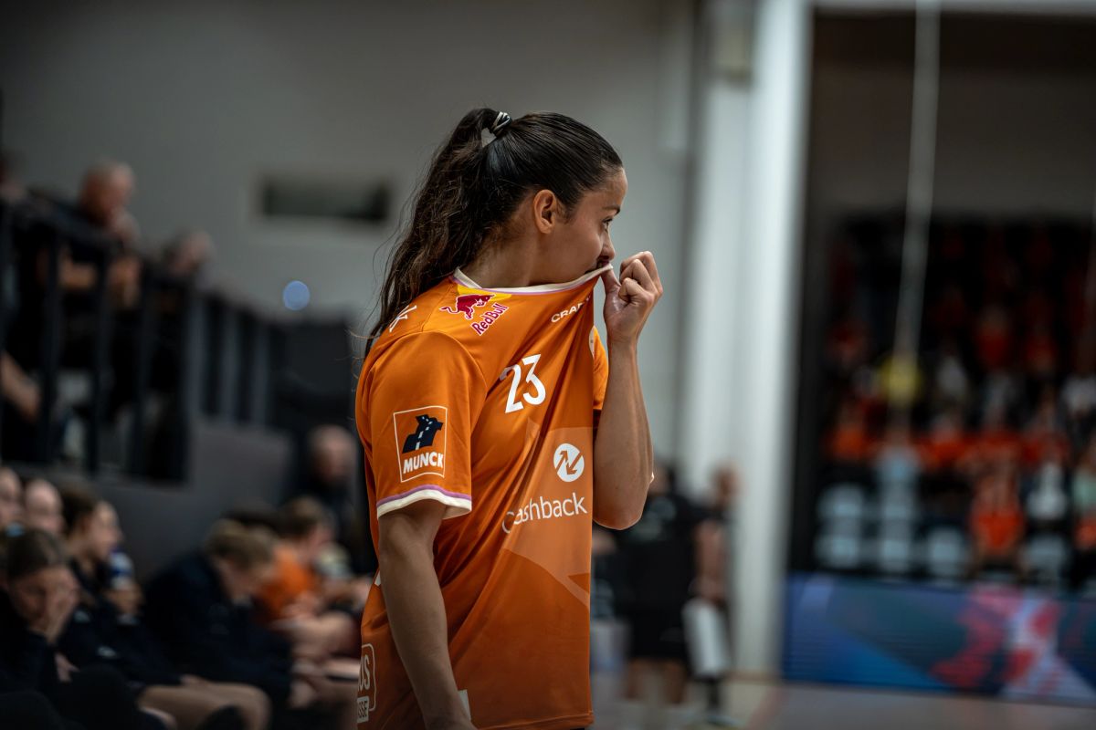 Spiller i orange trøje i en sportshal.