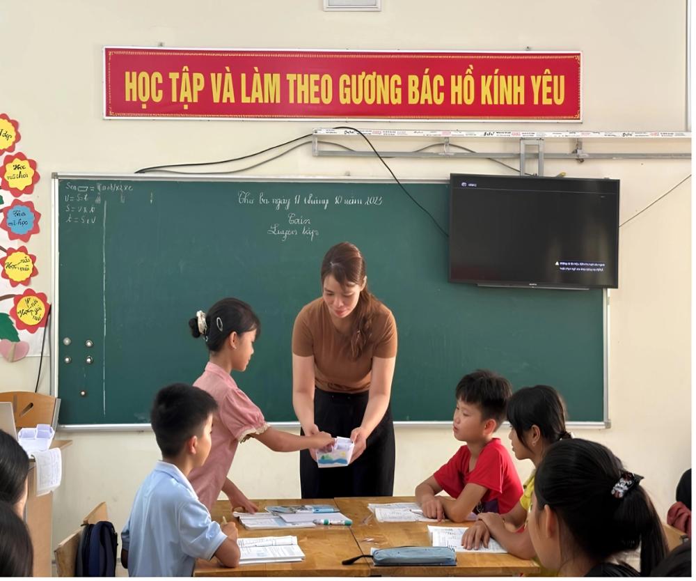 Ms. Nguyen Thi Lan’s students receive their math homework from a secret gift box. 