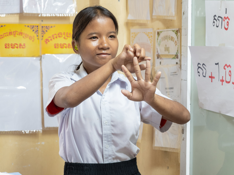 Srey Oun communicates with her teacher and classmates using sign language during a lesson.