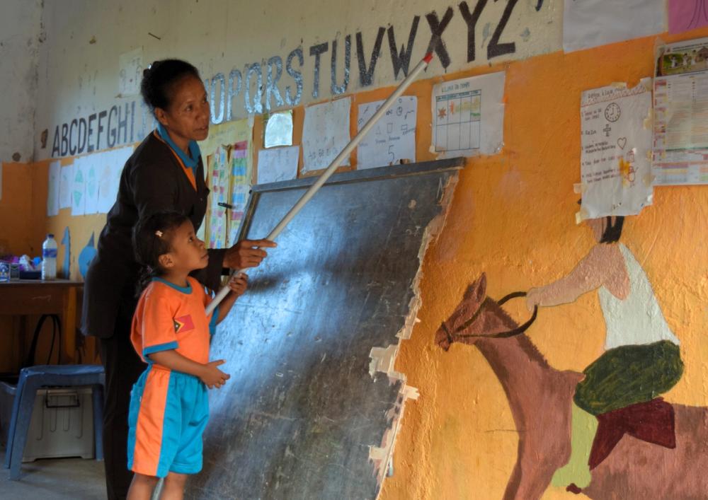 Carolina teaching a student the alphabet in Lautem municipality, Timor-Leste.