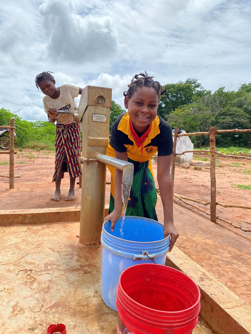 Ana (pictured above) and her friend now only have to walk minutes to collect water from their community's new borehole system.
