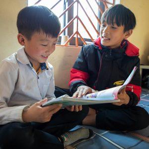Binh helping his roommate with his studies.