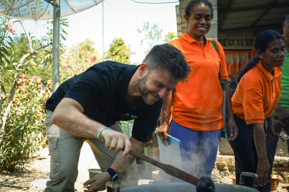 Juan cooking with members of the Mothers Support Group. On the menu: a nourishing porridge dish packed with chicken, beans, vegetables and local superfoods like moringa. . Photo: Sambath Tep.