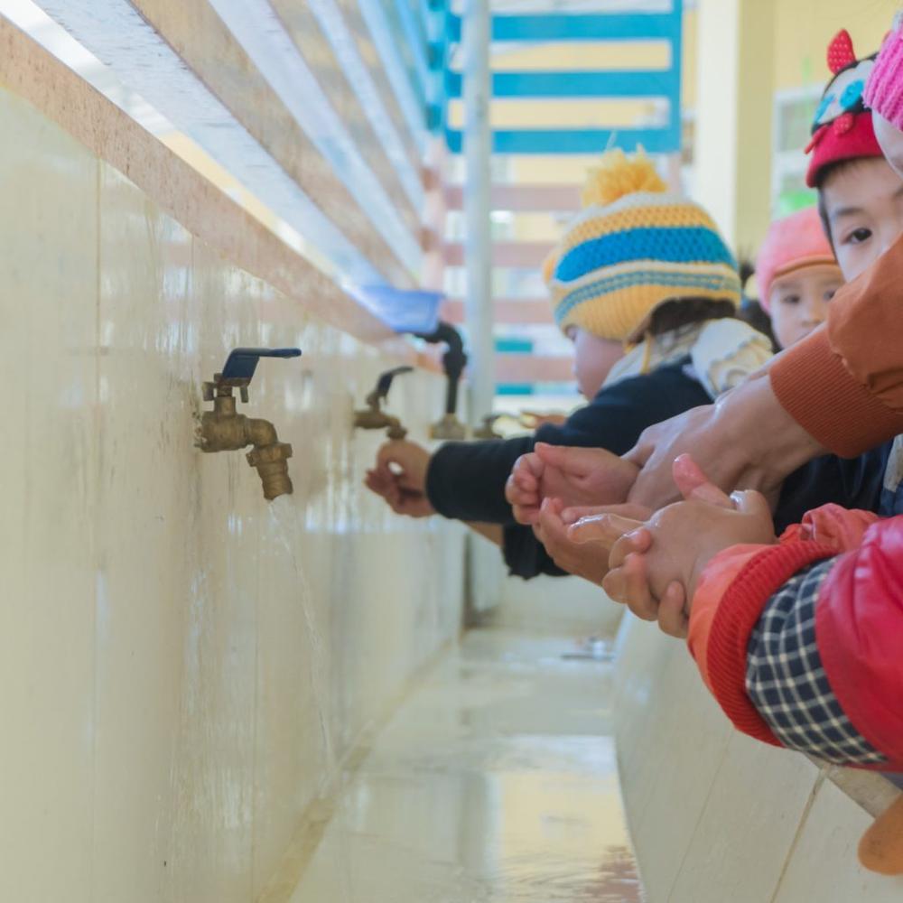 Children washing their hands at the school to stay healthy.