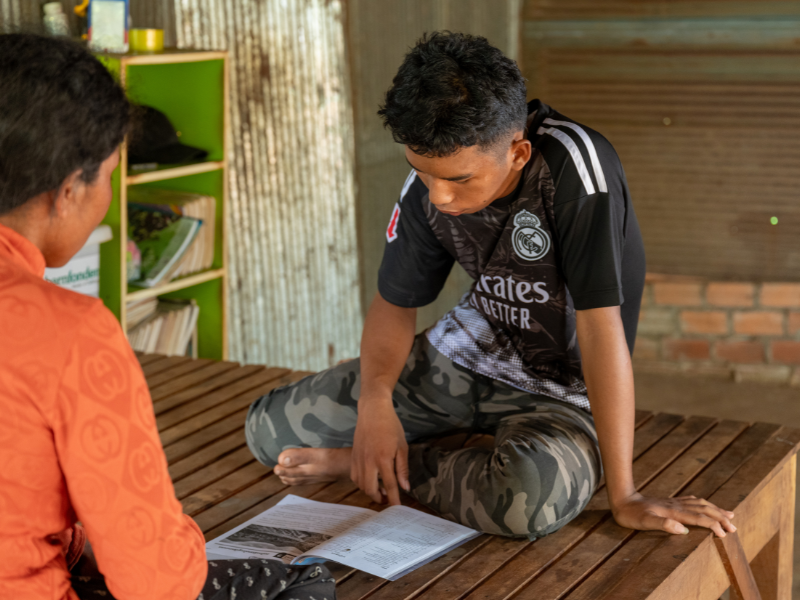 Bros Aun does his homework at home with his mother, who helps him keep learning and moving forward.