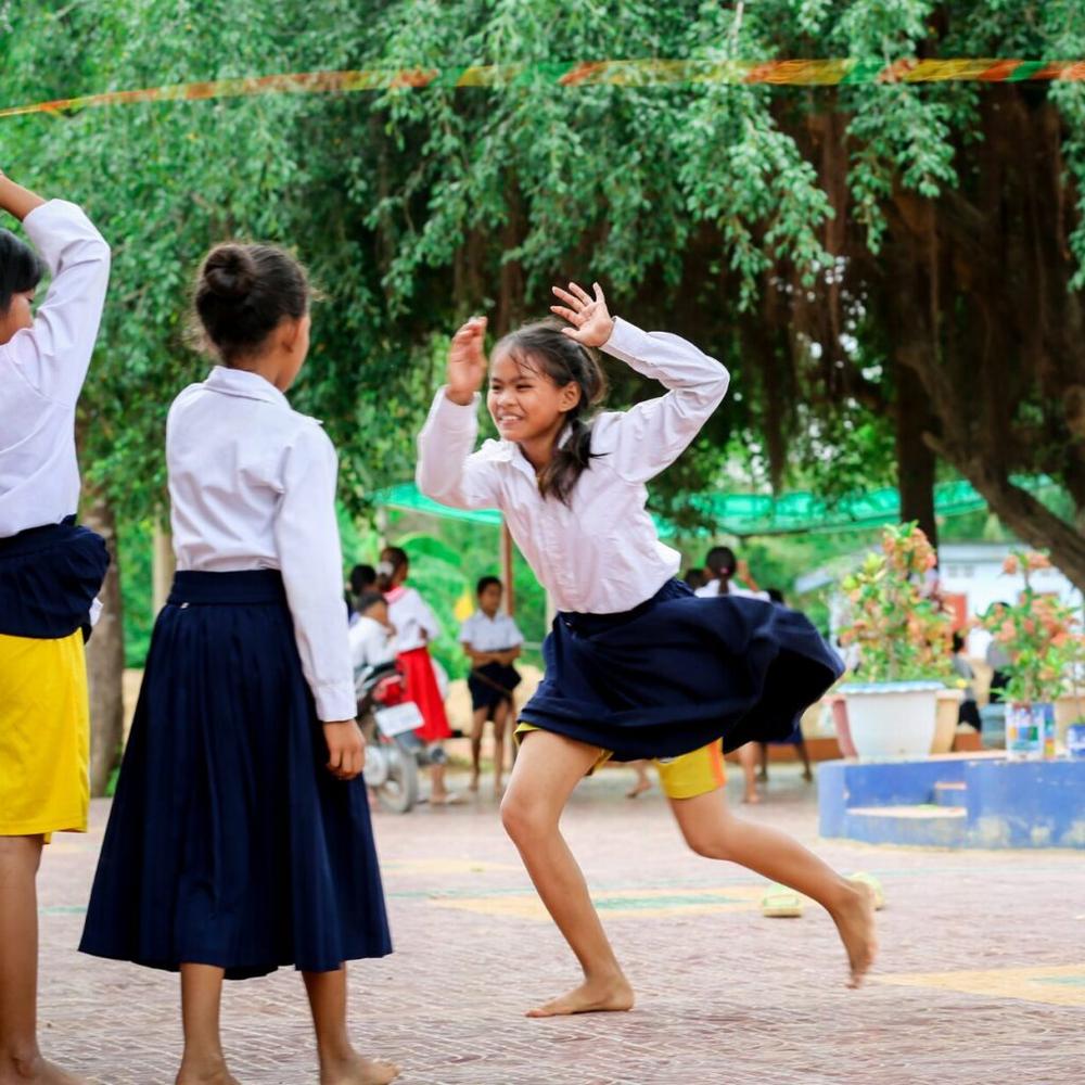 Chenda (pictured right) skips rope with her new school friends in rural Cambodia.