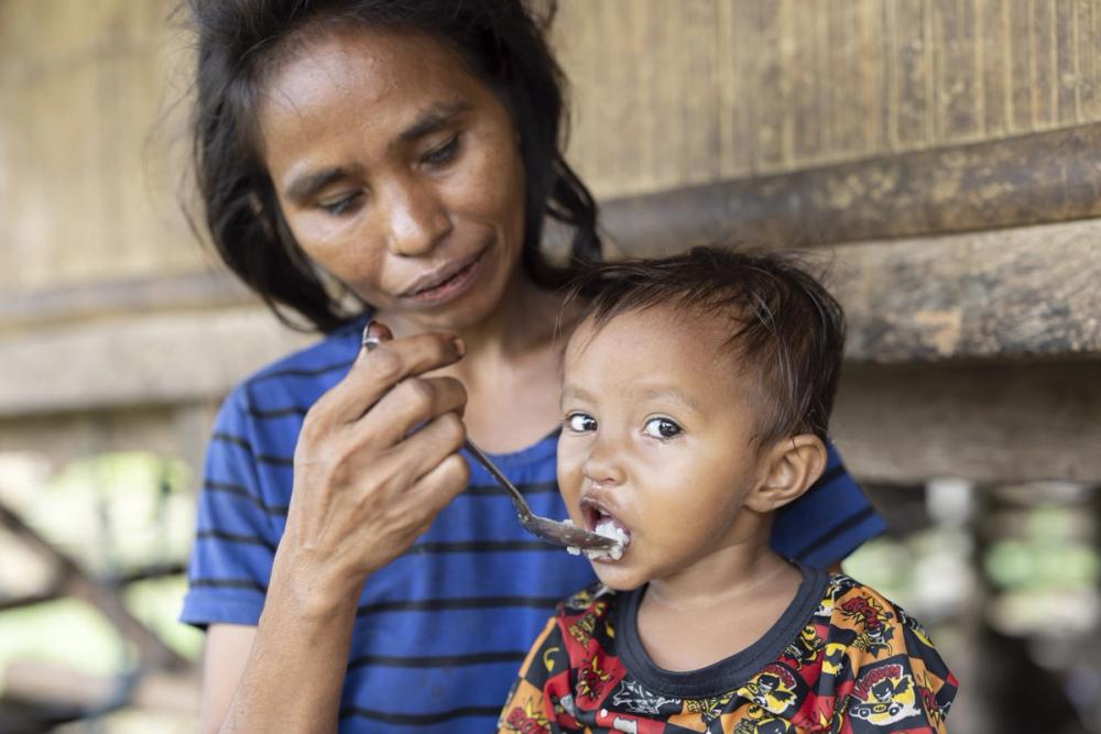 Mum feeding her baby a nutritious meal to improve health and wellbeing,
