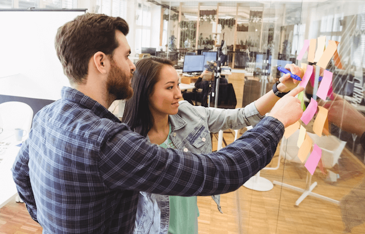 A BA clarifying requirements with a product owner, one of the ways business analysts and Scrum teams come together.