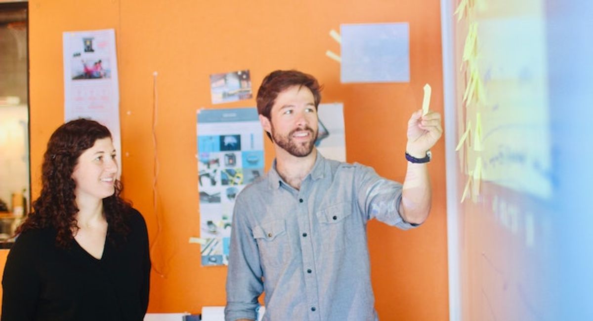 Team members at a whiteboard while taking part in an Individual strengths retrospective. Photo by Tool Inc on Unsplash.