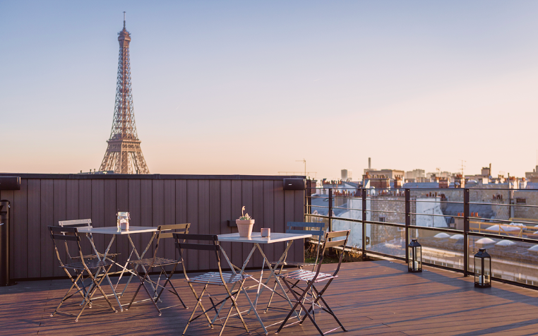 Une terrasse parisienne avec vue iconique sur la Tour Eiffel, pensée comme un espace de respiration au cœur de l’expérience Comet. Entre lumière naturelle, mobilier épuré et panorama exceptionnel, l’image évoque un cadre privilégié pour se retrouver, échanger ou prolonger un événement dans une atmosphère élégante et détendue.