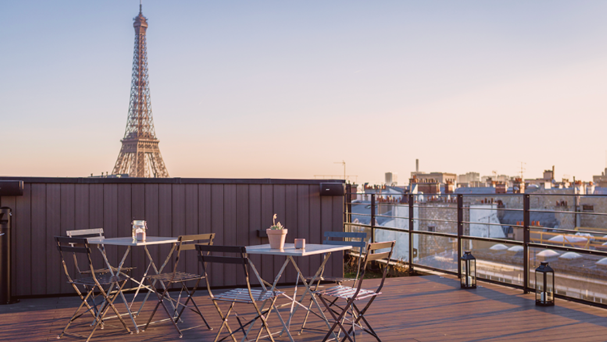 Une terrasse parisienne avec vue iconique sur la Tour Eiffel, pensée comme un espace de respiration au cœur de l’expérience Comet. Entre lumière naturelle, mobilier épuré et panorama exceptionnel, l’image évoque un cadre privilégié pour se retrouver, échanger ou prolonger un événement dans une atmosphère élégante et détendue.