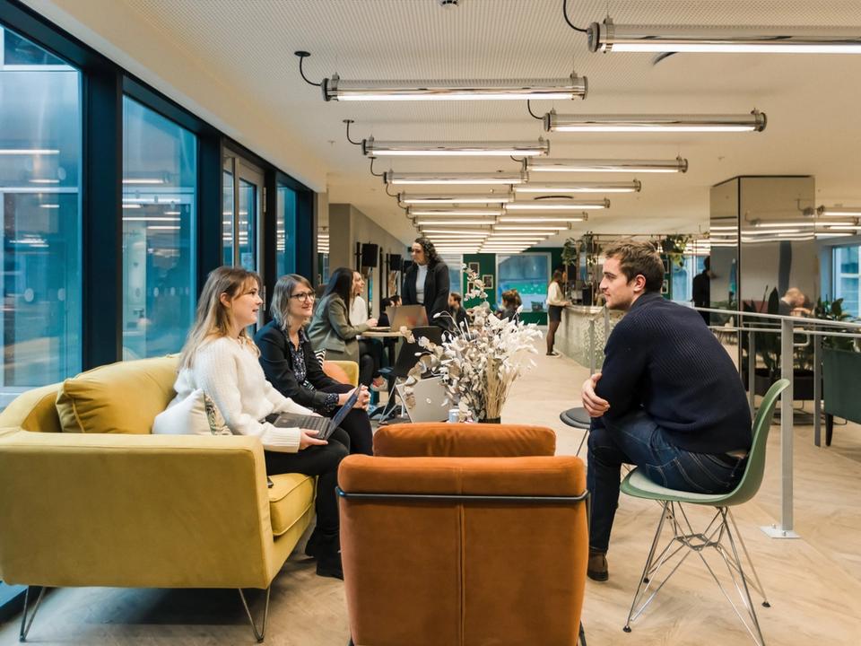 Échange professionnel dans un espace hospitality chaleureux chez Comet Landscape