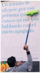 Un colleur applique au balai-brosse une affiche dédiant une minute de silence à la personne qui a parlé une minute le micro éteint.