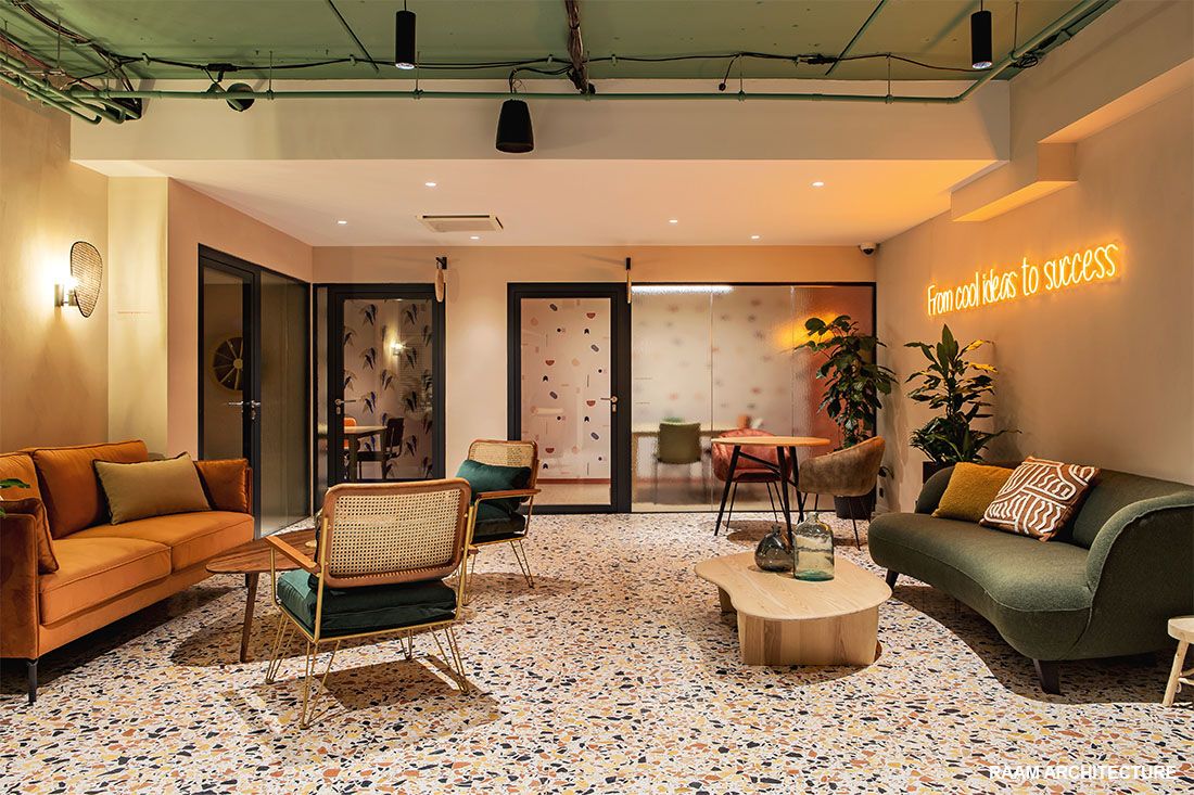 Salon d’accueil premium avec canapés, plantes et néon décoratif chez Comet Workplaces Bercy