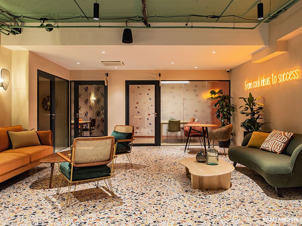 Salon d’accueil premium avec canapés, plantes et néon décoratif chez Comet Workplaces Bercy