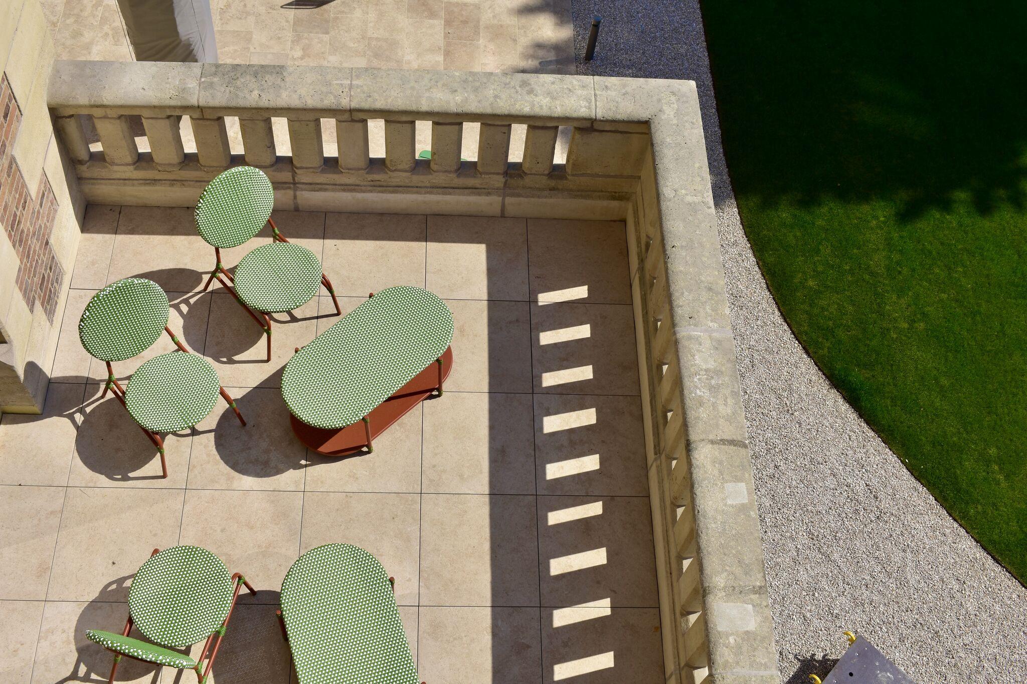 Overhead view of the terrace at Le Grand Comet and its green garden furniture