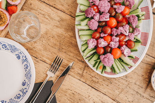 Une mise en scène gourmande et colorée autour d’une table conviviale. Les légumes frais, joliment disposés, évoquent une cuisine saine, généreuse et de saison, pensée pour accompagner les moments de partage dans une atmosphère chaleureuse et décontractée.