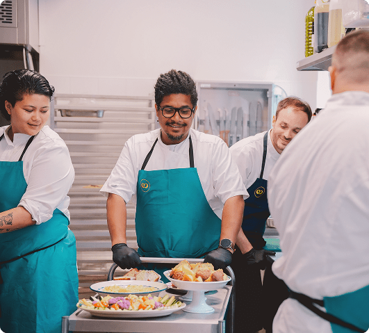 Dans les coulisses de Comet Food, l’équipe s’affaire avec précision et convivialité autour du dressage des plats. Entre savoir-faire, attention portée aux détails et esprit d’équipe, l’image traduit une cuisine vivante, soignée et profondément humaine.