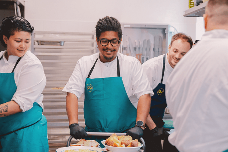 Dans les coulisses de Comet Food, l’équipe s’affaire avec précision et convivialité autour du dressage des plats. Entre savoir-faire, attention portée aux détails et esprit d’équipe, l’image traduit une cuisine vivante, soignée et profondément humaine.