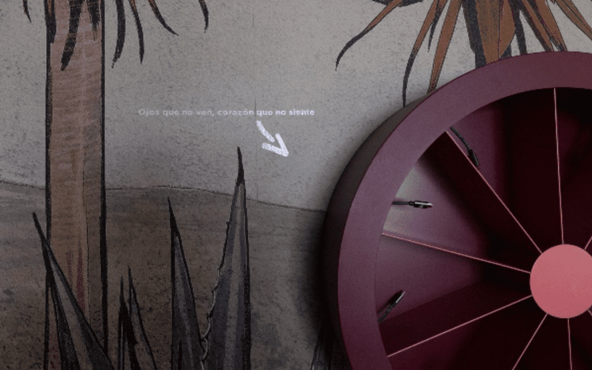 Un détail de décoration murale : une fresque de palmiers et d'agaves, une phrase projetée en espagnol et une grande roue murale bordeaux.