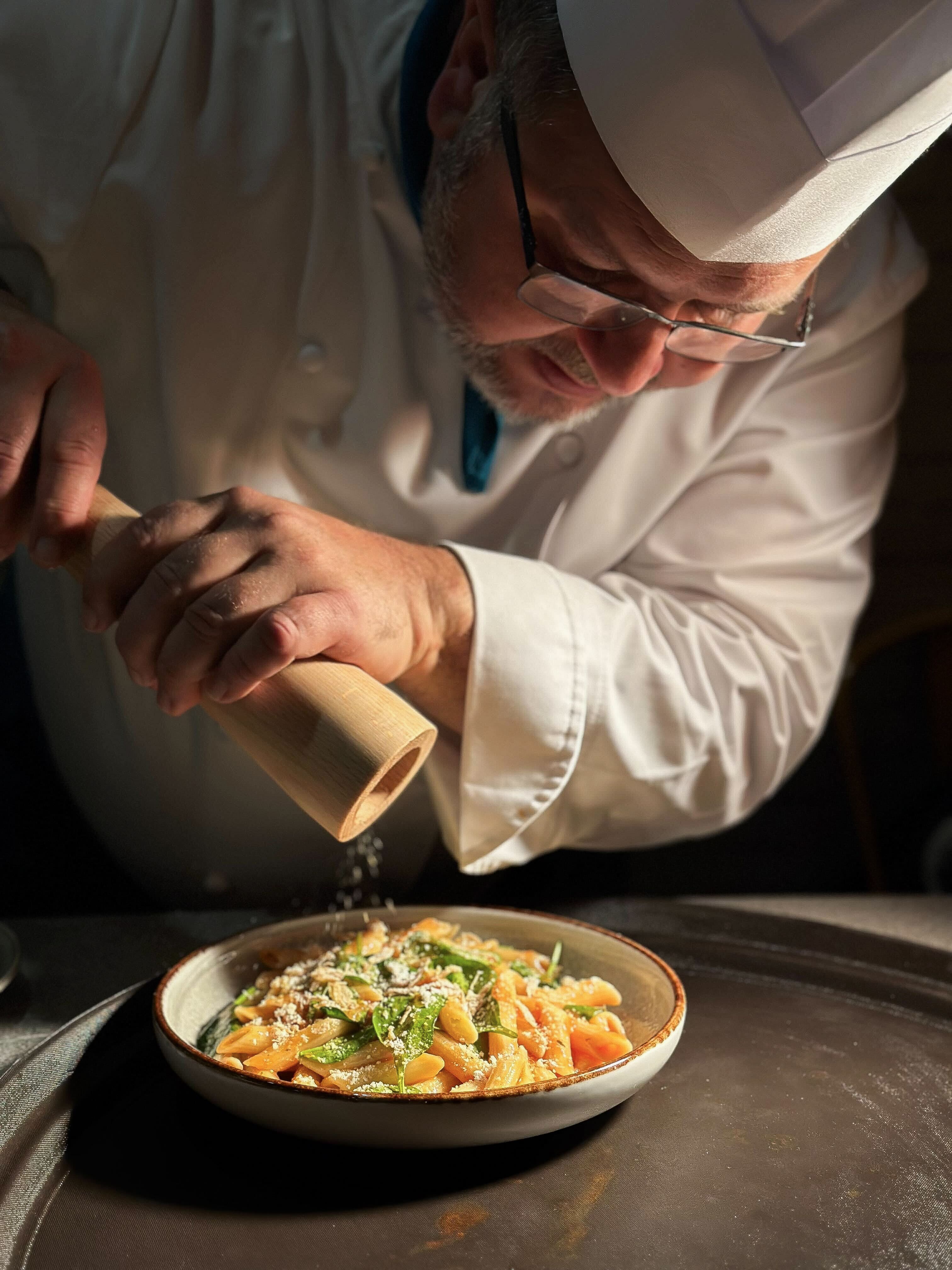 Le chef Vakhtang Meliava dresse une assiette et ajoute une touche de poivre avant l'envoi.