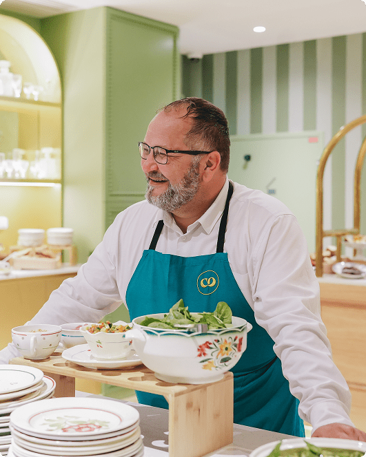 Le chef Vakhtang Meliava au cœur de l’expérience culinaire Comet : une présence chaleureuse, un service attentif et une cuisine pensée pour créer du lien. L’image met en avant l’humain derrière le buffet, dans une ambiance conviviale, élégante et naturellement accueillante.