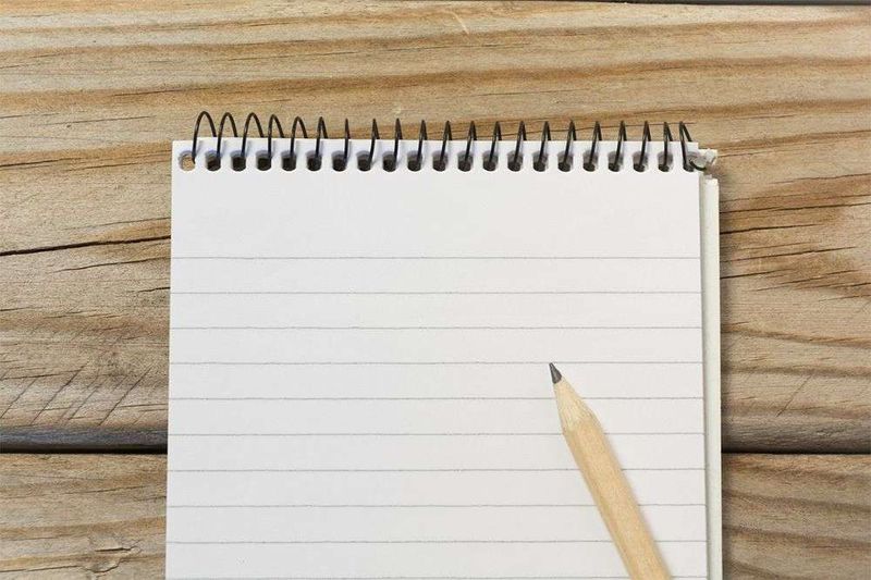 Note pad and pencil laid out on a desk.