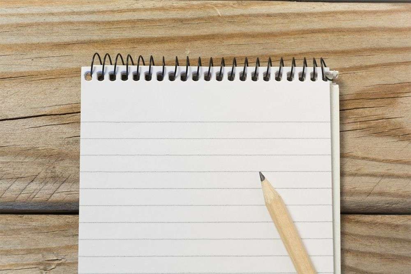 Note pad and pencil laid out on a desk.