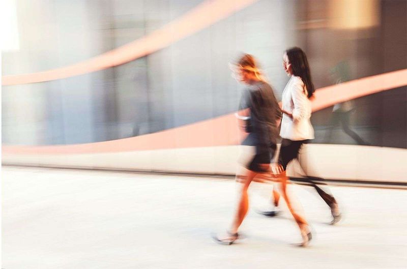2 people walking down a corridor.