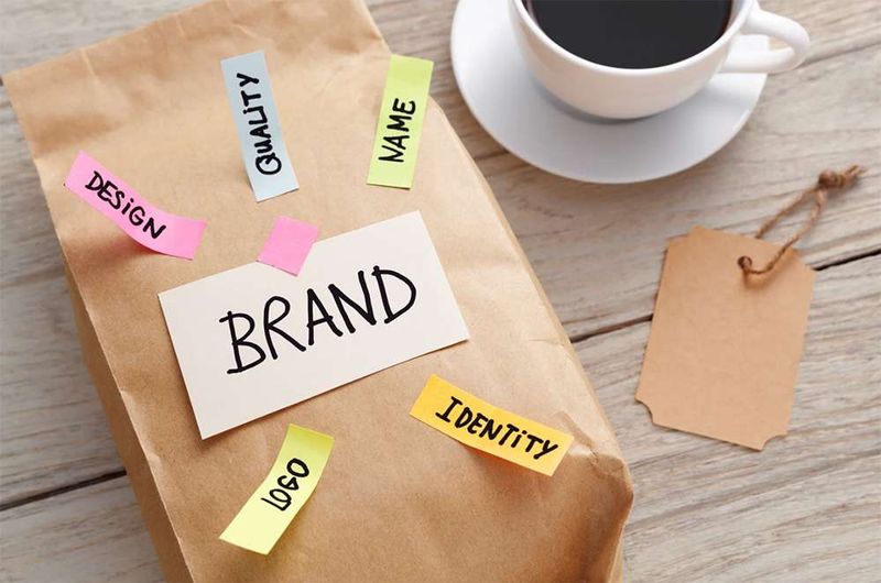 Brown paper bag with post=it notes stuck including the word Brand.