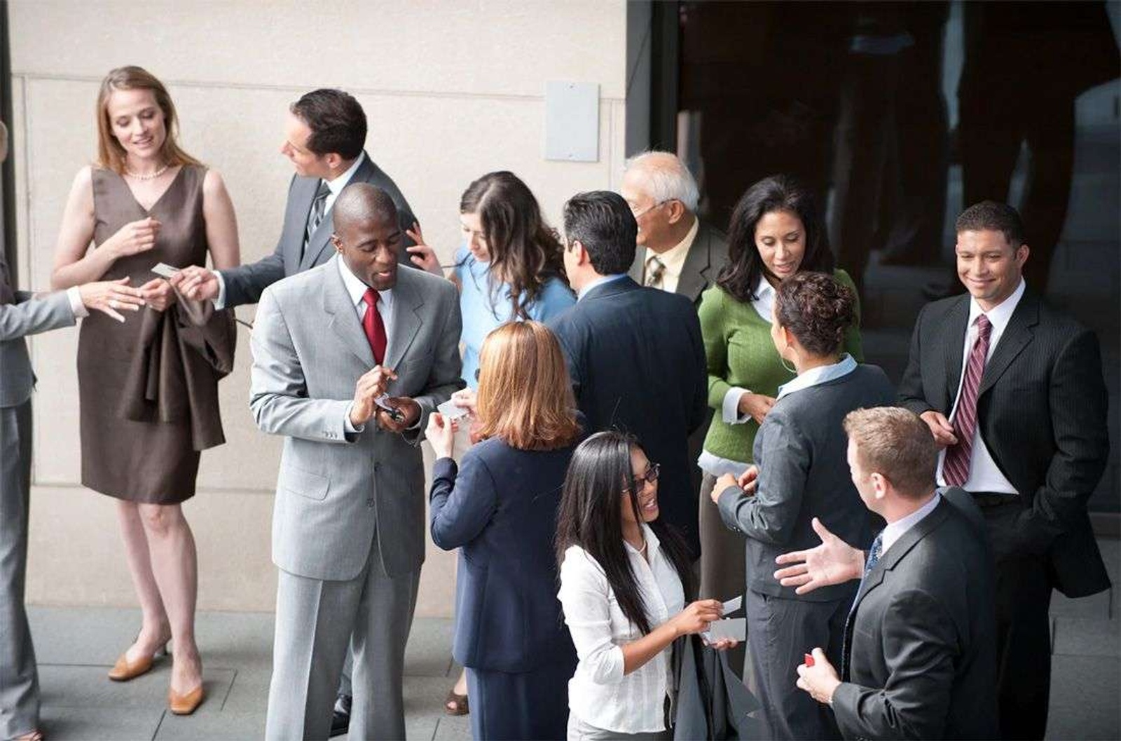 A diverse group of business people networking outside.
