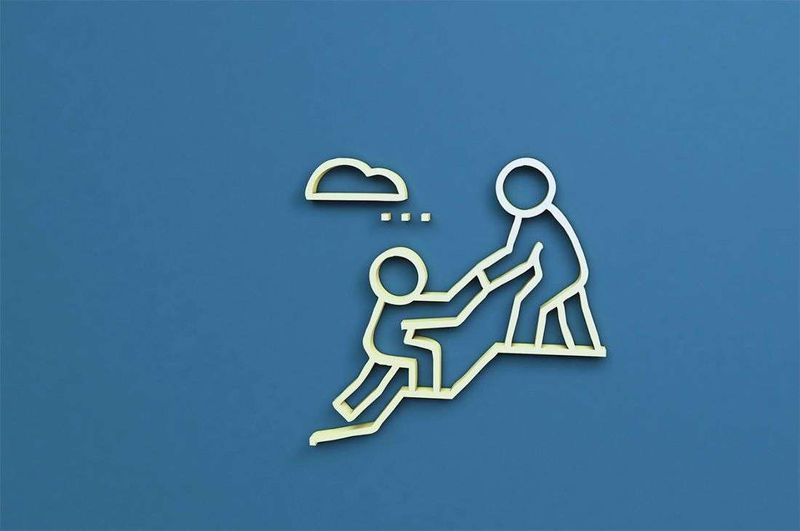 a plastic character helping another character up a hill with a rain cloud.