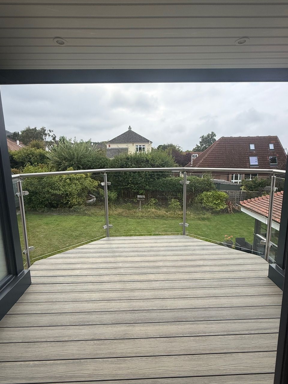 Sheltered balcony with timber decking and garden views at Fernielaw Avenue