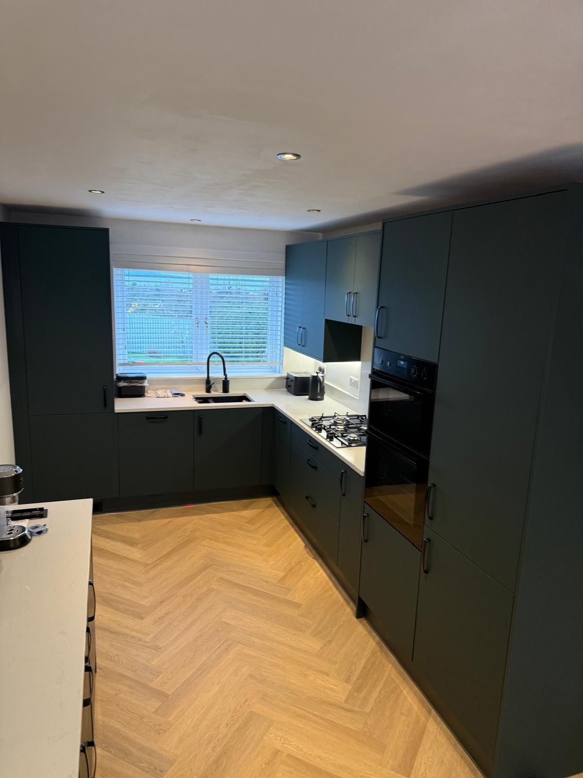 Integrated oven, tall storage and base units in a Wren kitchen installation