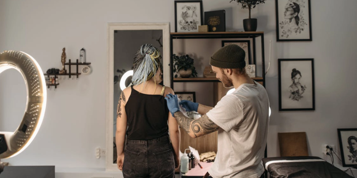 tatoueur avec un client après avoir utilisé la meilleure application de réservation pour tatoueurs