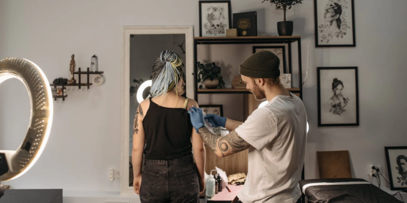 tatuador com um cliente após usar o melhor aplicativo de agendamento para tatuadores