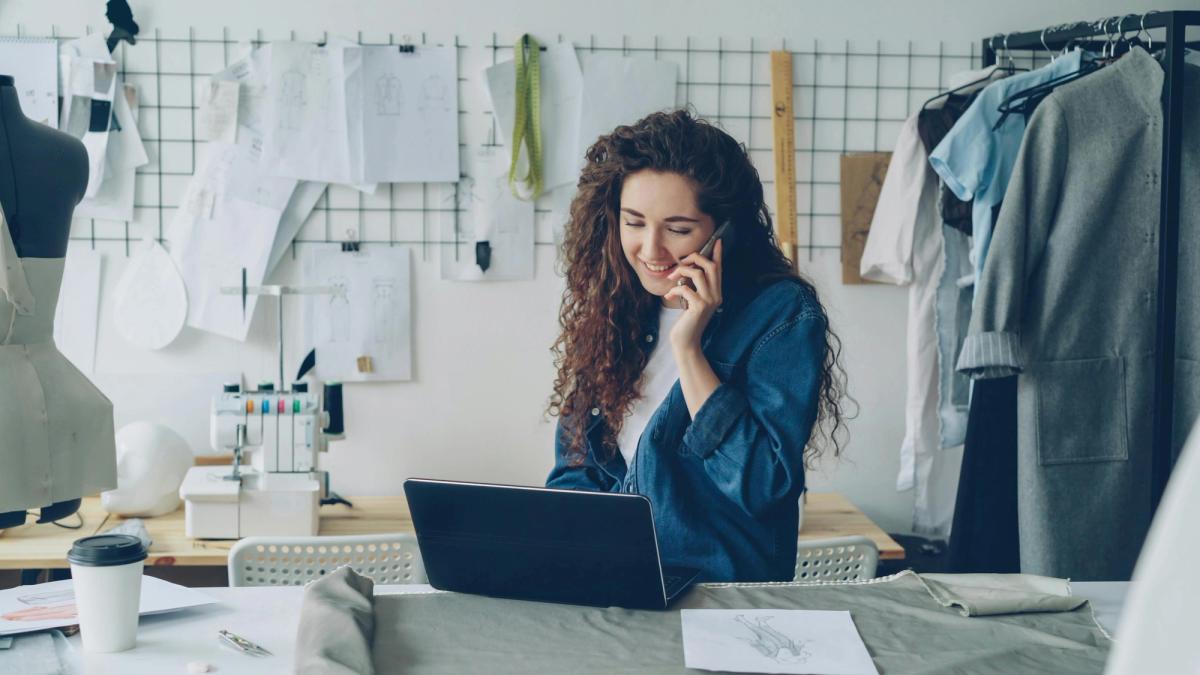 woman with curly hair on the phone with client using best scheduling app for small business